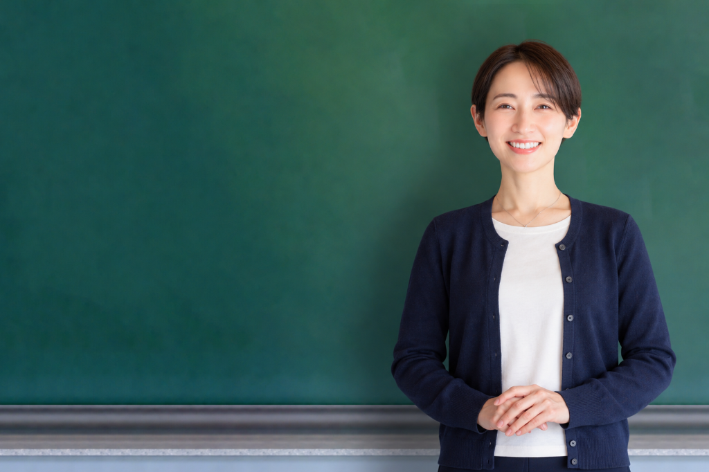 黒板の前で笑顔で立つ女性講師